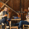 Two young women enjoy tea winter cottage wooden sunny outdoor